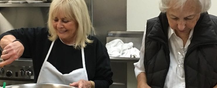 A senior citizen volunteers to help prepare food for the homeless.
